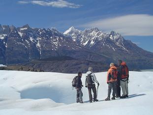David conversando con algunos pasajeros. al fondo se ve, a la derecha, las cumbres nevadas del Paine Grande y a la izquierda el cordn Olgun