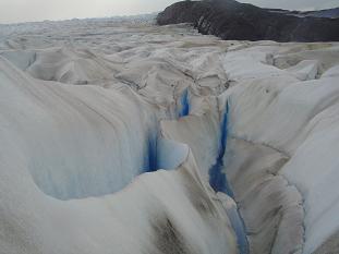 Las grietas van apareciendo producto del movimiento del glaciar. Al fondo se ve uno de los nunatak que dividen el frente del glaciar