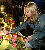 Una joven enciende esta noche una vela por fuera del instituto escenario de la tragedia ( REUTERS )