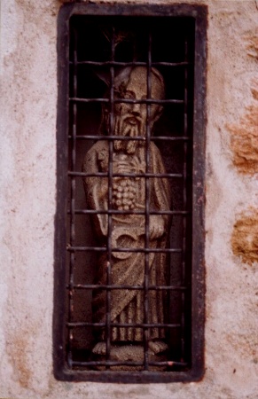 Jesus as grape harvester - statue in building wall in Couchey