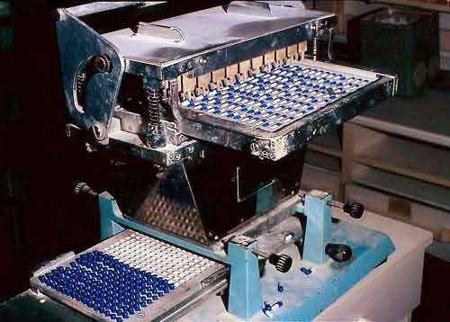 Figure A) One machine separates the capsule halves, sorts and places them into separate trays.