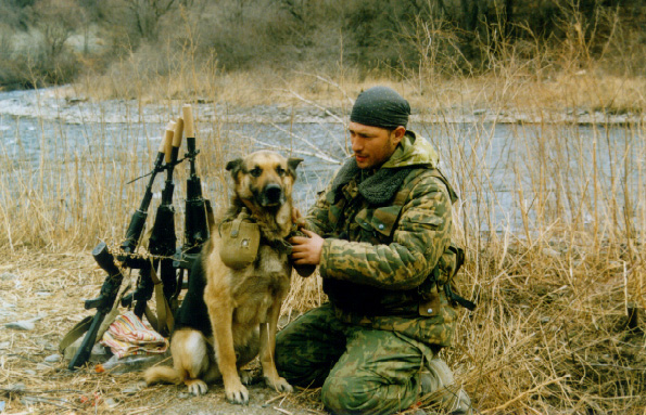 Russian soldier pets a watchdog