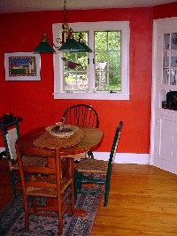 Dining room with two windows, built-in corner cupboard and entrance to living room and kitchen
