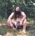 Rabbit skin loincloth, outdoors seated on log, thumbnail