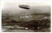 Postcard showing the GRAF ZEPPELIN in flight over Friederichshafen, Germany,  with the zeppelin works in the background.    Click to see an actual-size picture.