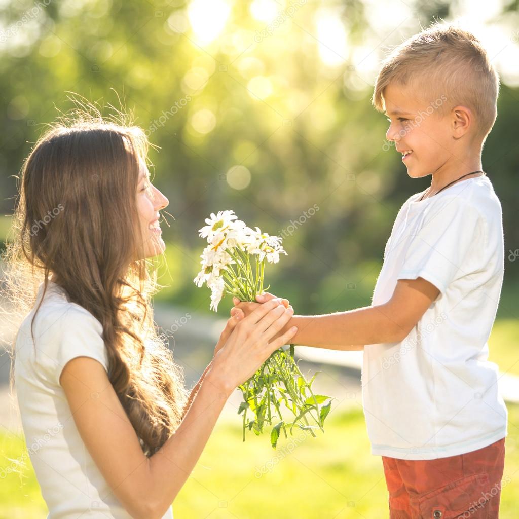Ребенок дарит цветы маме